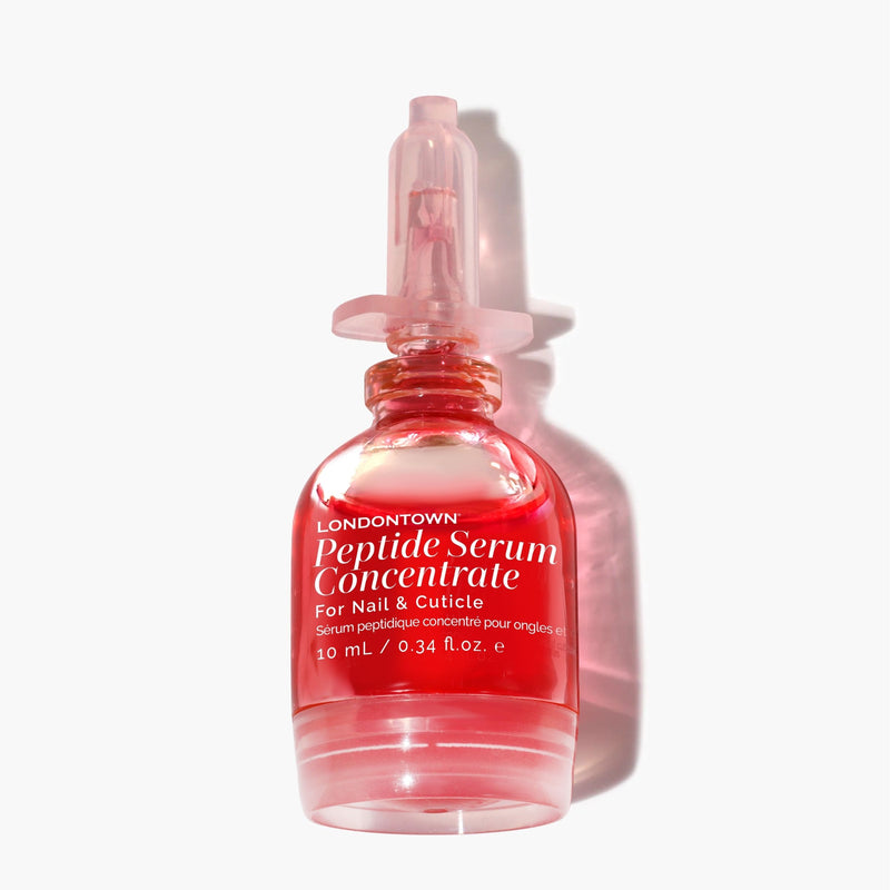 A 10 mL clear pink bottle with a dropper cap, labeled “LONDONTOWN Peptide Serum Concentrate,” containing an advanced nail and cuticle serum formulated to support repair and recovery.