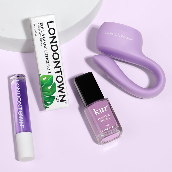 The Violet Vibes Trio by LONDONTOWN promises sheer purple perfection with cuticle oil, purple polish, lip balm, and a sleek LED nail lamp for flawless nails on a light surface in just 5 minutes.