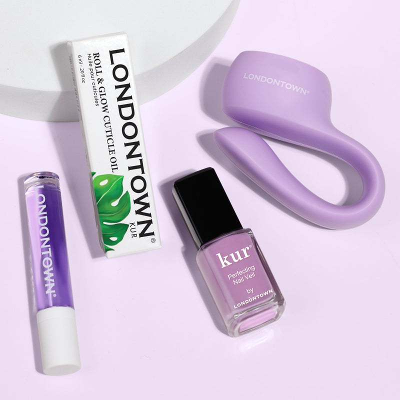 The Violet Vibes Trio by LONDONTOWN promises sheer purple perfection with cuticle oil, purple polish, lip balm, and a sleek LED nail lamp for flawless nails on a light surface in just 5 minutes.