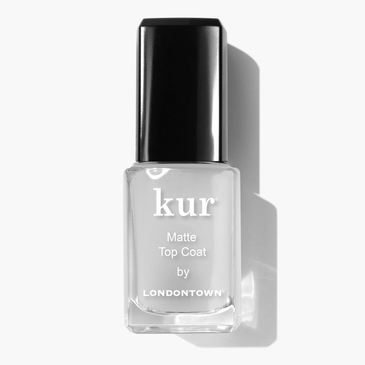 A bottle of LONDONTOWN Matte Top Coat nail polish, featuring a black cap and clear bottle label on a white background, offering an ultra-luxe, suede-like finish.
