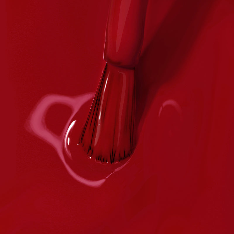 A close-up of LONDONTOWN's Mull It Over brush applying decadent burgundy nail polish on a glossy surface.