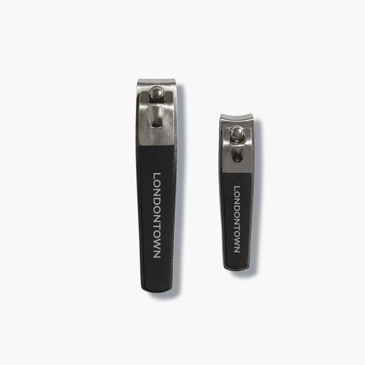 The LONDONTOWN Nail Clipper Duo Set - Black features two metal nail clippers with black handles, displayed side by side on a white background for a precise cut every time.