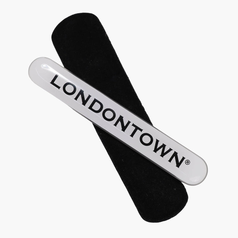 A Glass Nail Buffer from LONDONTOWN designed with a black surface and a white handle, featuring the brand name in bold letters, perfect for smoothing and polishing your nails to a brilliant shine.