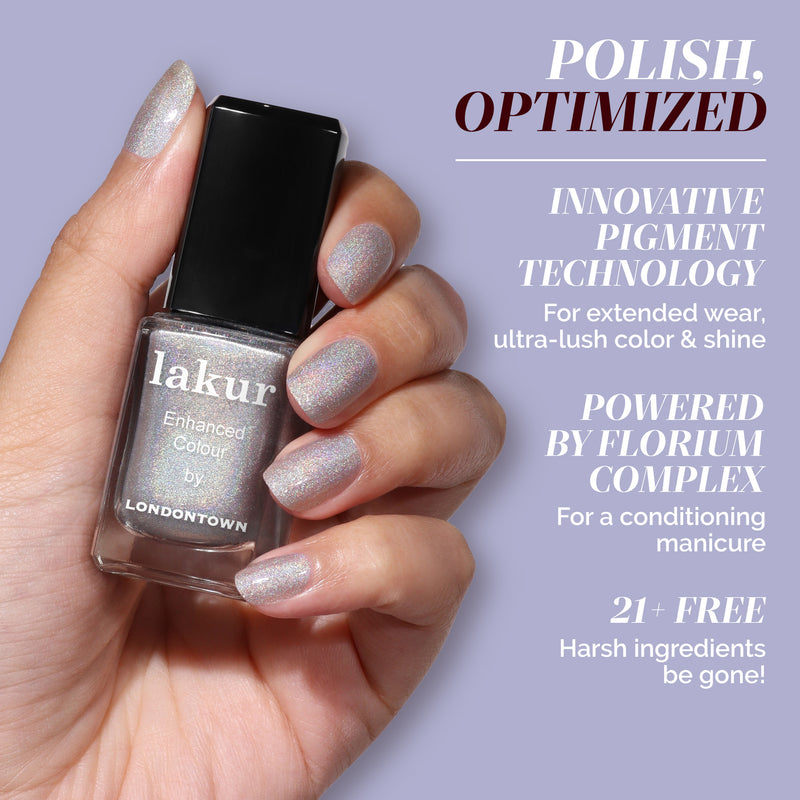 A hand with platinum holographic nails holds a LONDONTOWN lakur bottle in Nice & Icy. Text highlights its pigment technology, conditioning formula, and 21+ free ingredients for stunning nails.