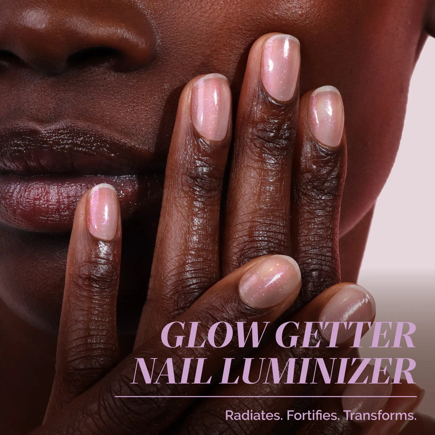 A close-up of a hand with glossy, pale pink nails touching a chin. Text: "One-Step Hero Minis by LONDONTOWN. Radiates. Fortifies. Transforms." Effortless beauty—nails as easy as your go-to hair color for instant confidence.