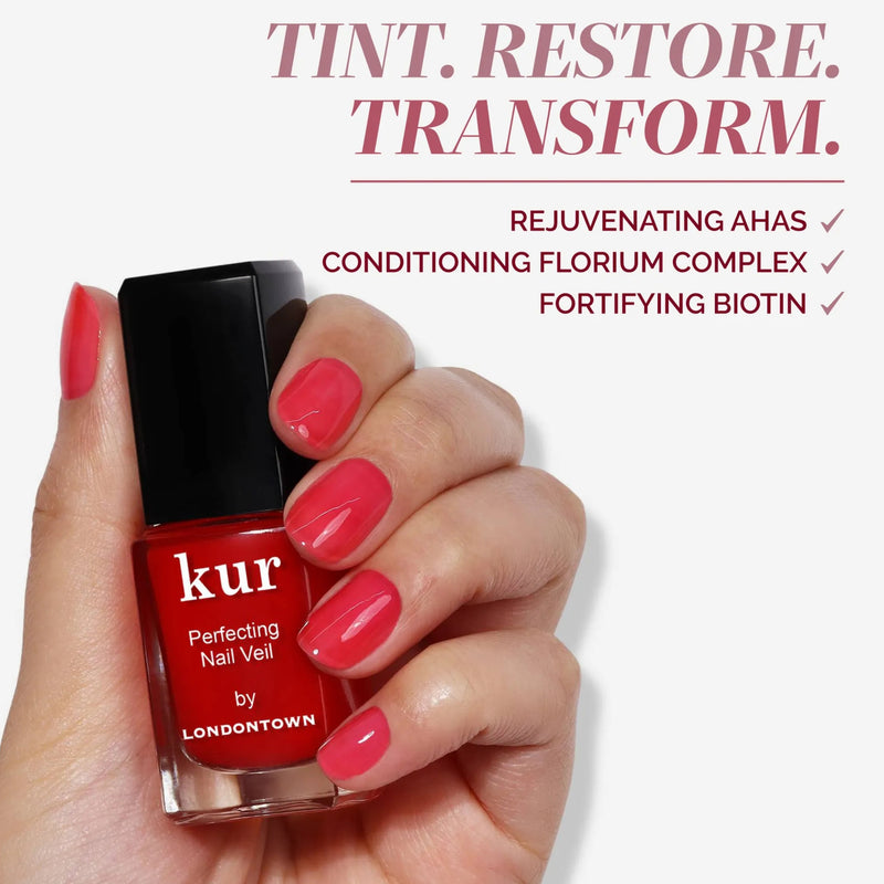 A hand with pink painted nails holds a bottle of LONDONTOWN Perfecting Nail Veil #8—an effortless nail care formula with rejuvenating AHAs, conditioning Florium Complex, strengthening biotin, and a sheer hint of color.