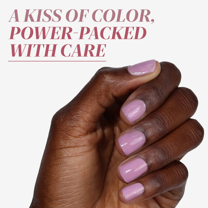 A hand with medium-length nails painted in LONDONTOWN’s Perfecting Nail Veil #9, a light pink polish, is shown beneath text that reads: "A kiss of color, power-packed with care and a hint of color.