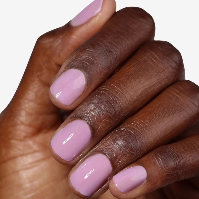 A hand with short, neatly manicured nails painted in LONDONTOWN's Perfecting Nail Veil #9—a glossy light pink polish that adds a subtle, power-packed pop of color.