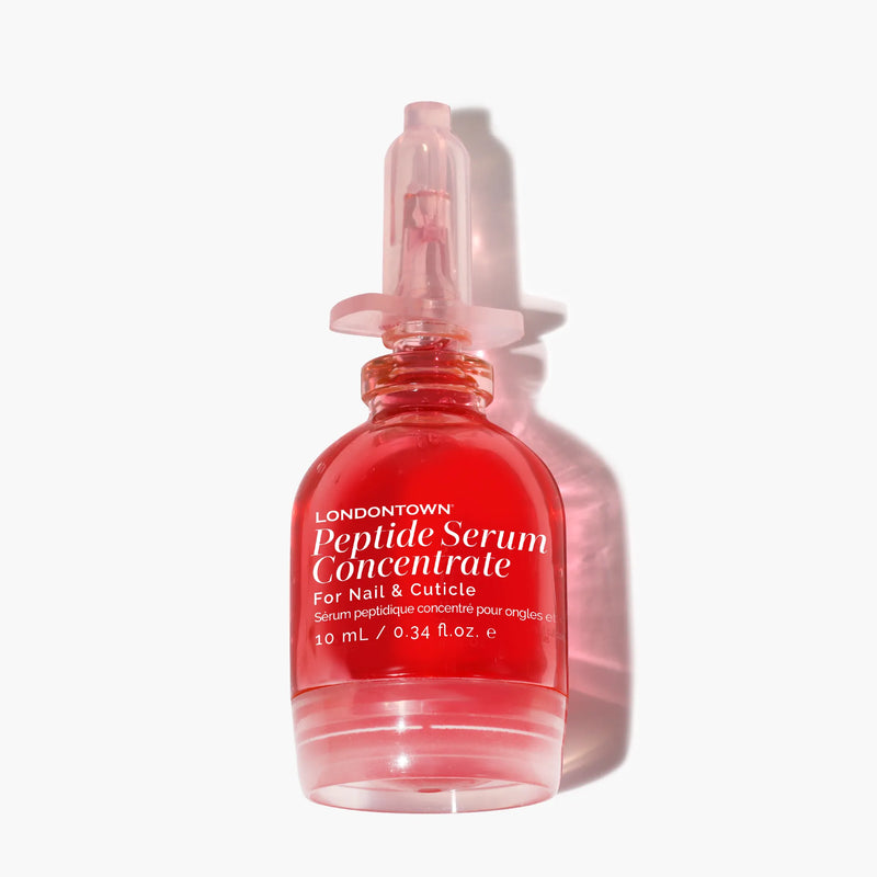 A 10 mL pink bottle of LONDONTOWN Peptide Serum Concentrate with a dropper cap—this nourishing serum supports nail repair and healthy growth.