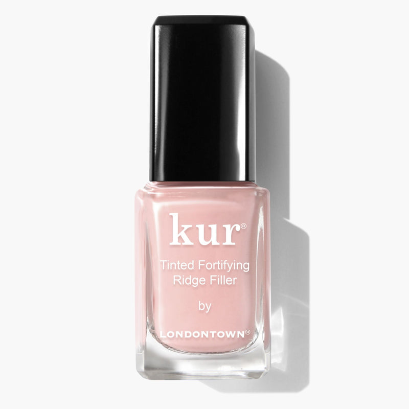 A LONDONTOWN Tinted Fortifying Ridge Filler - Petal Pink bottle offers a light pink tint and smooths nail ridges with ease, capped with a sleek black top.
