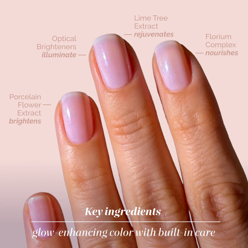 A close-up of three manicured fingers showcases LONDONTOWN’s Pink Illuminating Nail Concealer, labeled with key ingredients to illuminate, rejuvenate, and nourish—featuring an illuminating brightener for radiant nails.