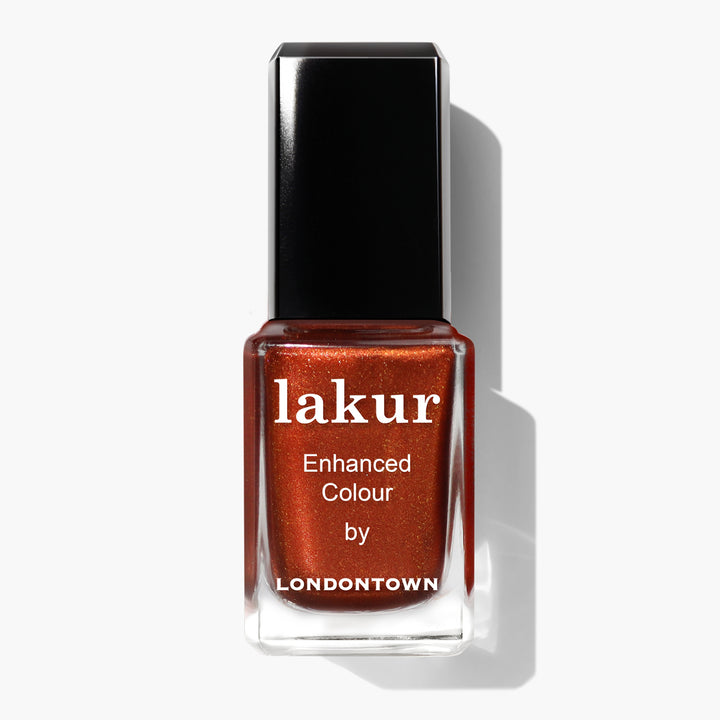 A bottle of Posh Forever by LONDONTOWN nail polish, featuring a metallic rust-red hue reminiscent of cinnamon, with a black cap and white text on the label.