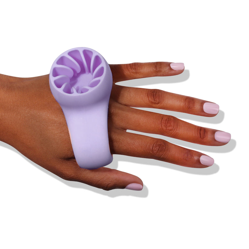 A hand wearing the Bottle Service Polish Holder - Purple by LONDONTOWN, crafted to ensure easy and mess-free manis, with its bristles facing inward.