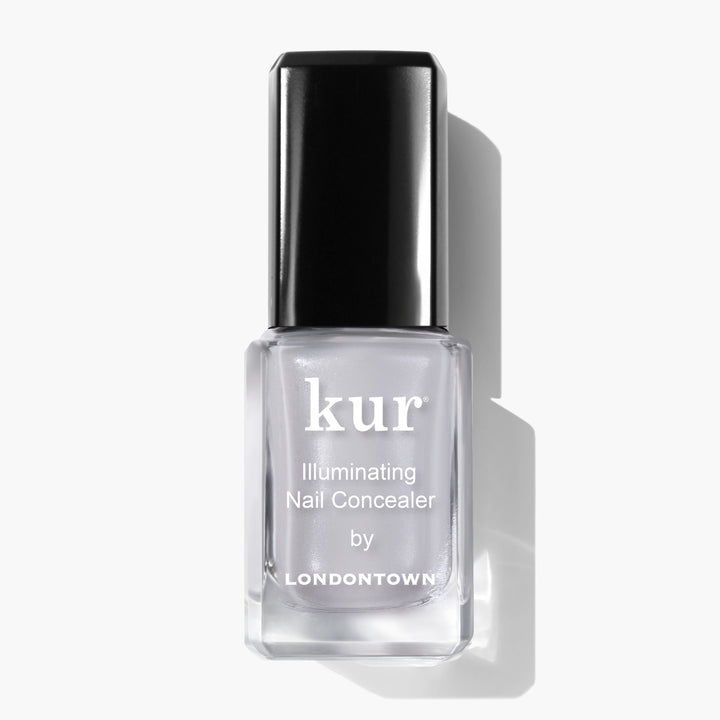 A bottle of LONDONTOWN Quartz Illuminating Nail Concealer, the instant nail perfector with a subtle soft gray glaze, featuring a sleek black cap on a white background.