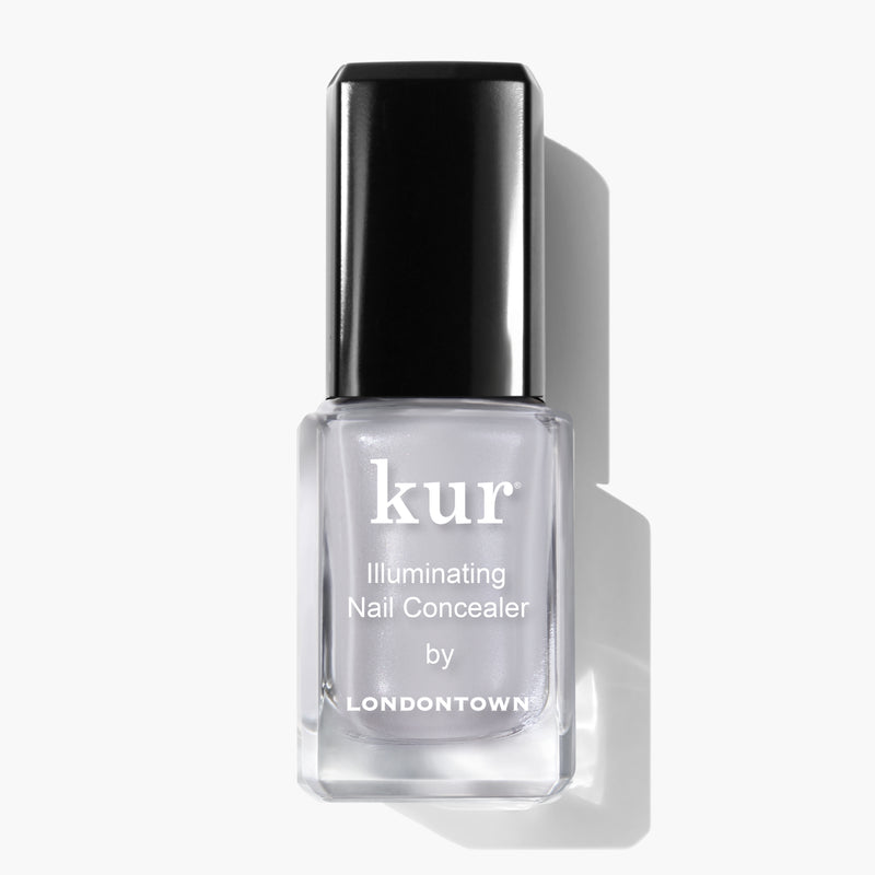A bottle of LONDONTOWN Quartz Illuminating Nail Concealer, the instant nail perfector with a subtle soft gray glaze, featuring a sleek black cap on a white background.