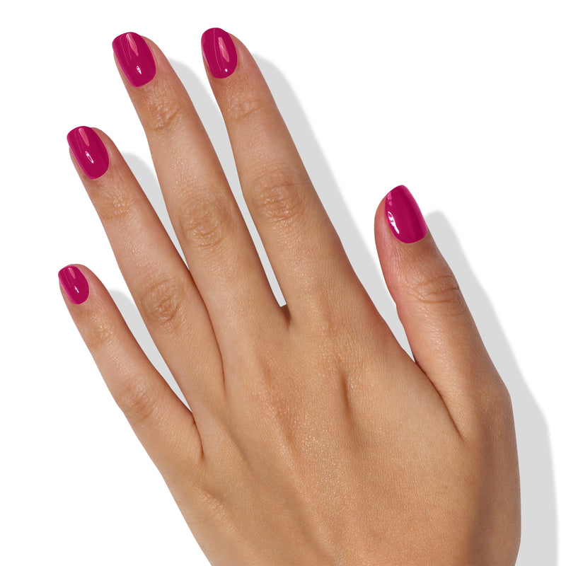 A hand with neatly manicured nails painted in the vibrant shade of Teeny 'Kini by LONDONTOWN, reminiscent of fruity sangria, against a white background.