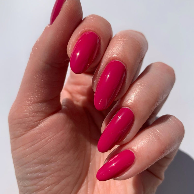 A close-up of a hand with long, oval-shaped nails painted in a glossy Teeny 'Kini color by LONDONTOWN.