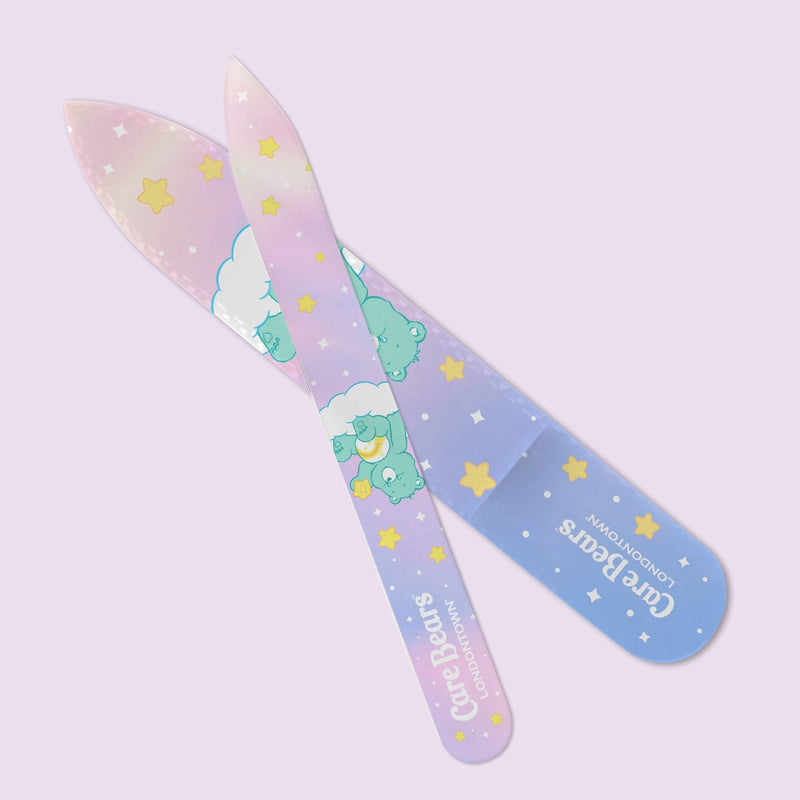 The LONDONTOWN Glass Nail File - Wish Bear features Care Bears, stars, and clouds in pastel colors on a light purple background—ideal for effortless nail filing and smooth, damage-free nails.