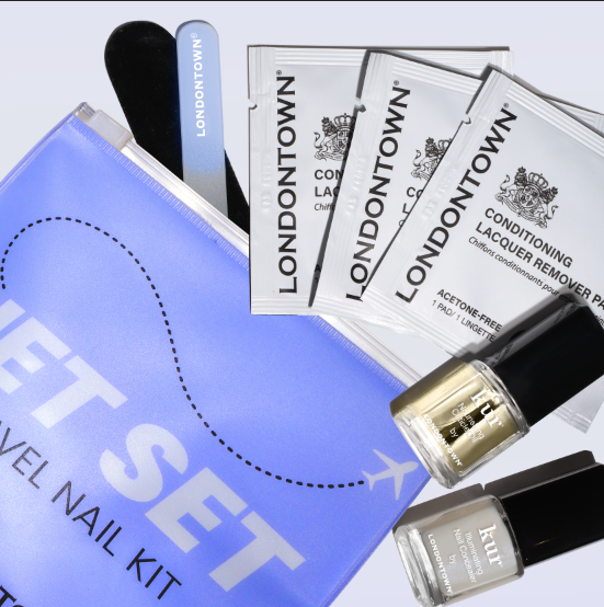 The LONDONTOWN Jet Set Travel Nail Kit includes a purple pouch, mini nail file, remover pads, and two neutral travel polishes—everything you need for manicures on the go.