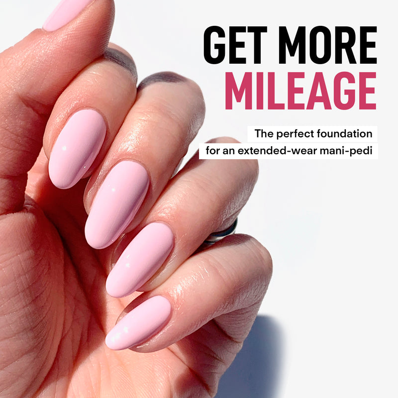 Close-up of a hand with long, pale pink manicured nails. Text reads: "LONDONTOWN Gel Genius Base Coat provides damage-free gel for an extended-wear mani-pedi.