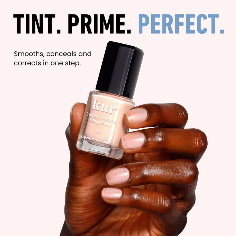 A hand holds a LONDONTOWN Tinted Fortifying Ridge Filler - Apricot Beige bottle against a beige background. Text reads: "TINT. PRIME. PERFECT." and "Smooths, conceals, and corrects ridges in one step.