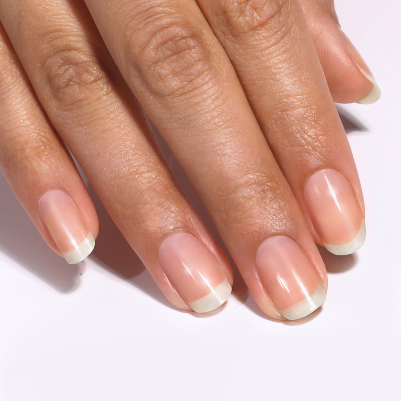 A close-up of a hand with natural, neatly buffed fingernails that shine polish-free against a light background, thanks to LONDONTOWN Smooth & Shine Buffer Pads.