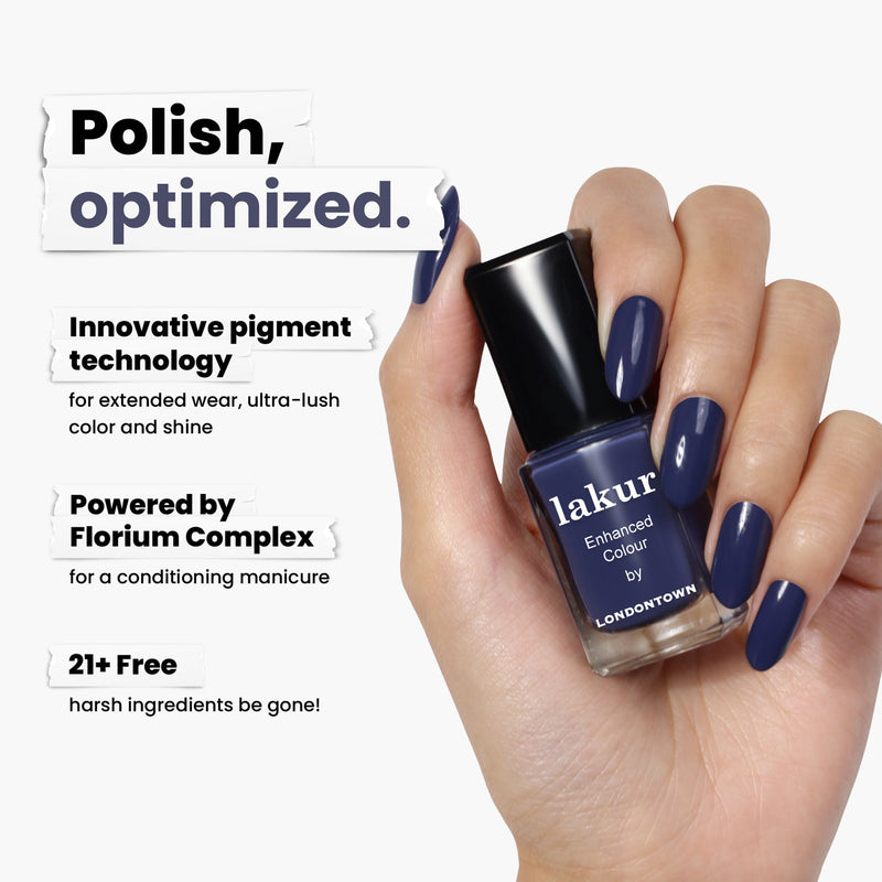 A hand holds a bottle of LONDONTOWN's Midnight Kiss nail polish in deep blue, showcasing innovative pigment technology powered by Florium Complex and free from 21+ harsh ingredients.