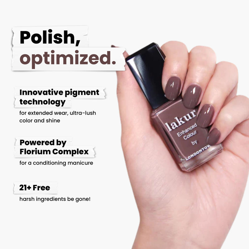 A hand holds a bottle of LONDONTOWN's Natural Charm, a brown nail polish. This vegan, cruelty-free formula features advanced pigment technology, the innovative Florium Complex, and a 21+ Free commitment for healthier nails.