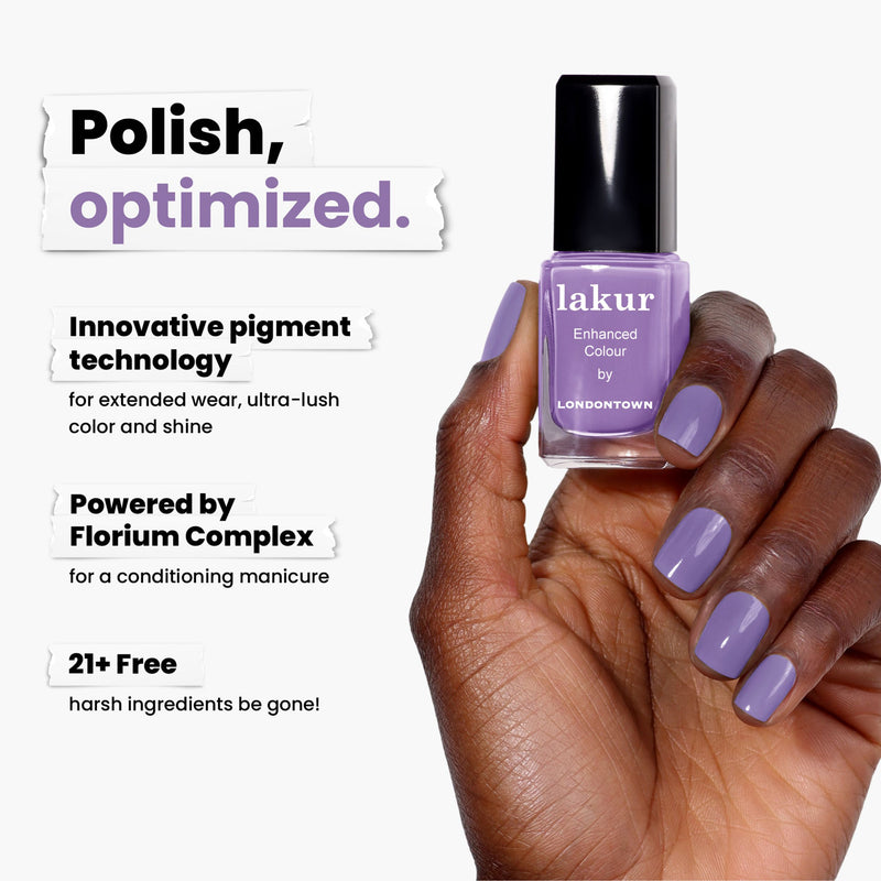 A hand with lavender-painted nails holds LONDONTOWN's Road Trip polish. It features innovative pigment technology, offers a conditioning manicure, and is free from harsh ingredients for an exciting twist on nail care.