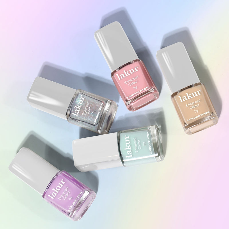 Five bottles from the LONDONTOWN Beary Polished Mini Set, inspired by collectible Care Bears, are arranged on a soft, rainbow gradient background.