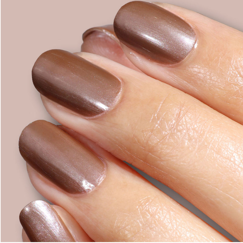 Close-up of a hand with neatly manicured nails painted in LONDONTOWN's Affogato, a shimmering java glow metallic taupe brown nail polish.