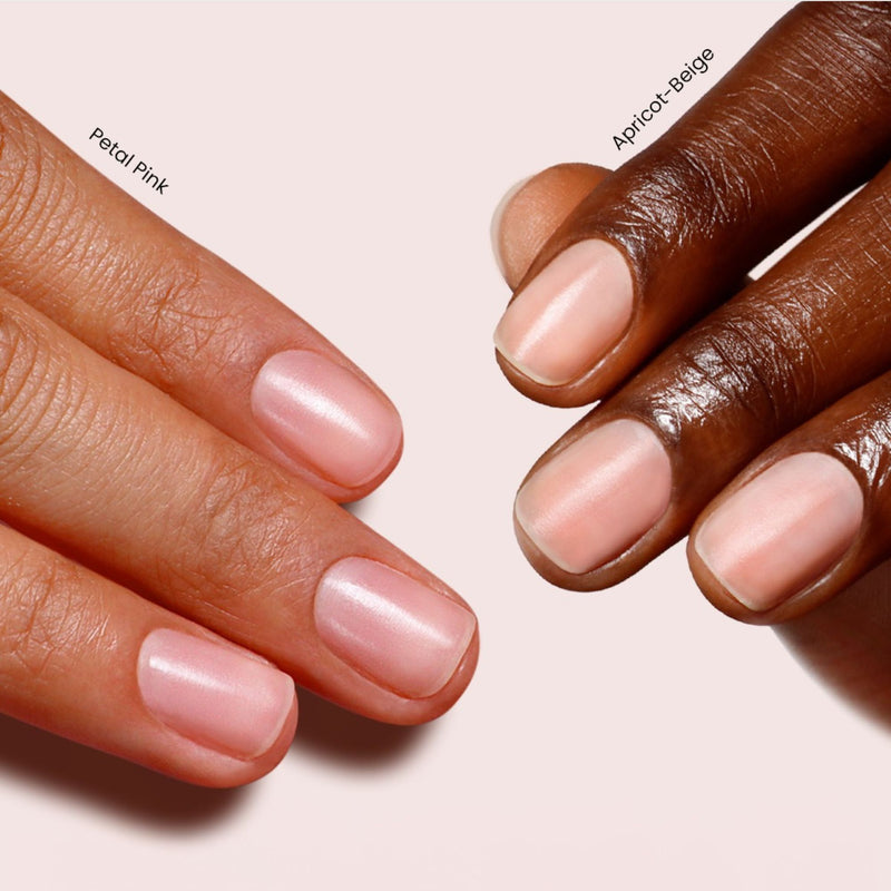 Two hands with manicured nails, in gentle shades labeled Petal Pink and Apricot-Beige, are displayed on a pale background, highlighting LONDONTOWN's Tinted Fortifying Ridge Filler - Apricot Beige’s delicate tint that complements their ridges perfectly.