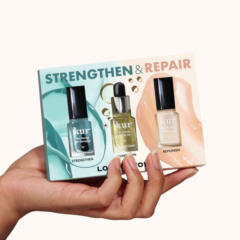 A hand holds the LONDONTOWN Strengthen & Repair Trio, a boxed set of three nail care products designed to boost strength and restore weak or brittle nails.