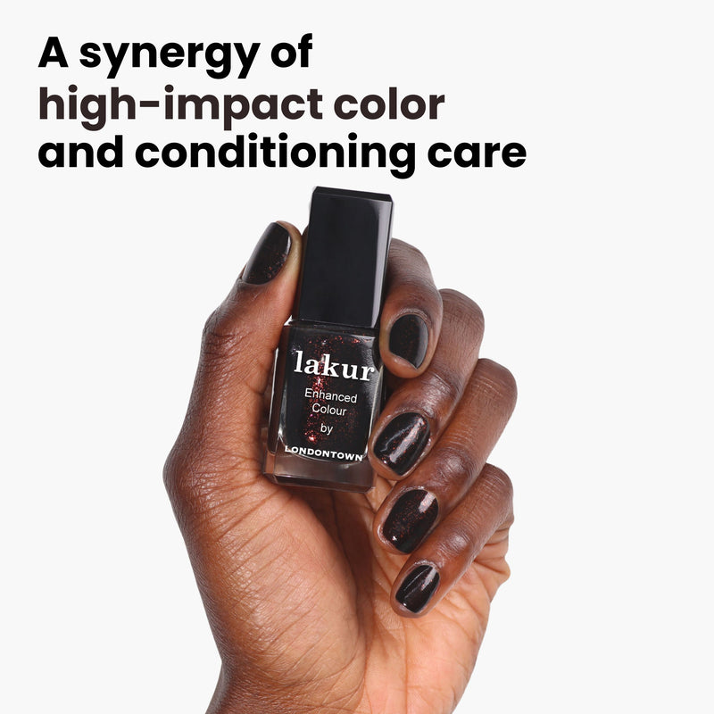 Hand holding "Around the Fireplace" by LONDONTOWN: A high-impact black nail polish enriched with deep brown hues and a copper-flecked shimmer for conditioning care.