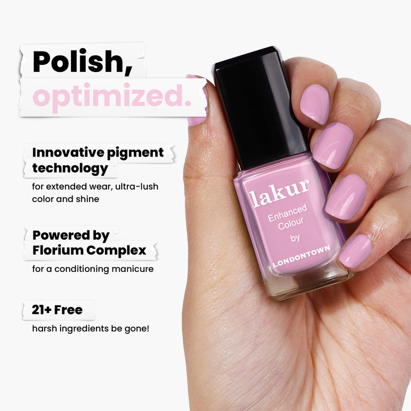 A hand holds a bottle of LONDONTOWN's Pink Palm nail polish, an exquisite carnation pink shade with innovative pigment technology powered by Florium Complex, and 21+ free from harsh ingredients.