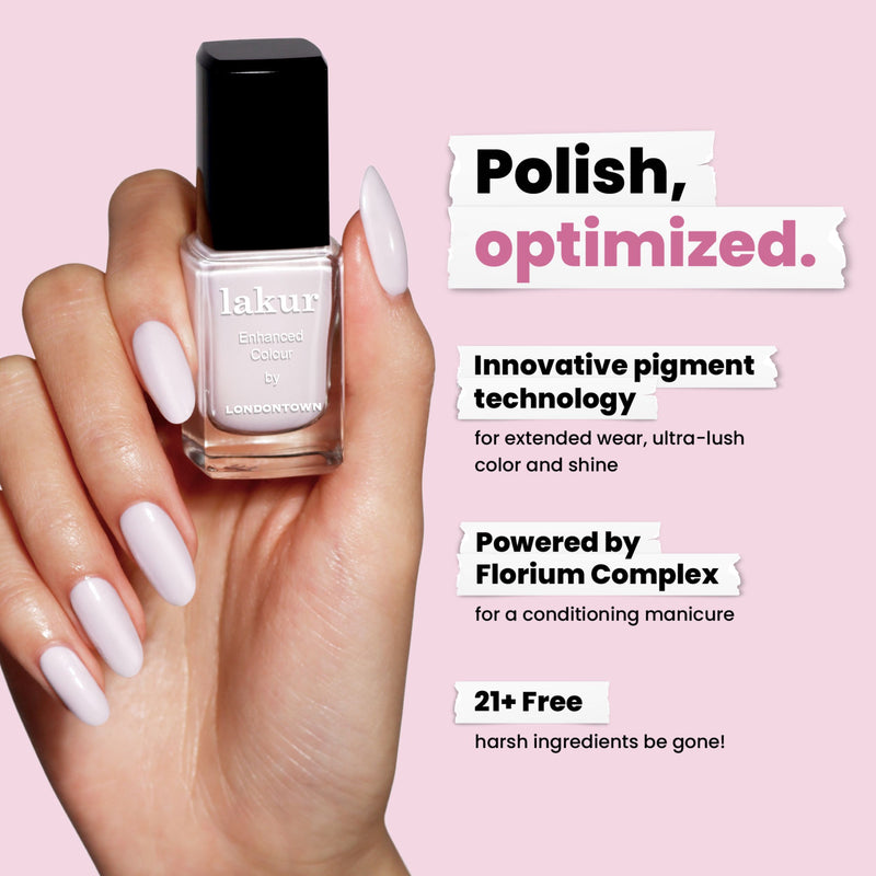 A hand with pastel purple nails holds a LONDONTOWN Strawberry Milk Lakur bottle; text highlights its milky pigment technology, conditioning formula, and that it's made without 21+ harsh ingredients.