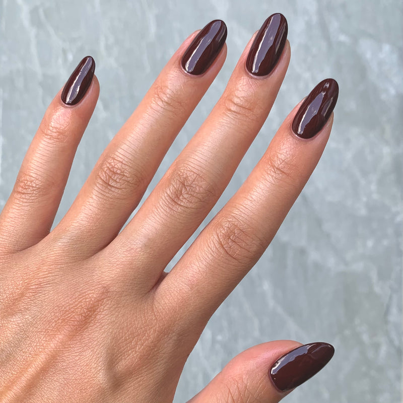 A hand flaunting long, oval nails painted with LONDONTOWN's Elderberry polish evokes depth and mystery, reminiscent of a blackened purple twilight.