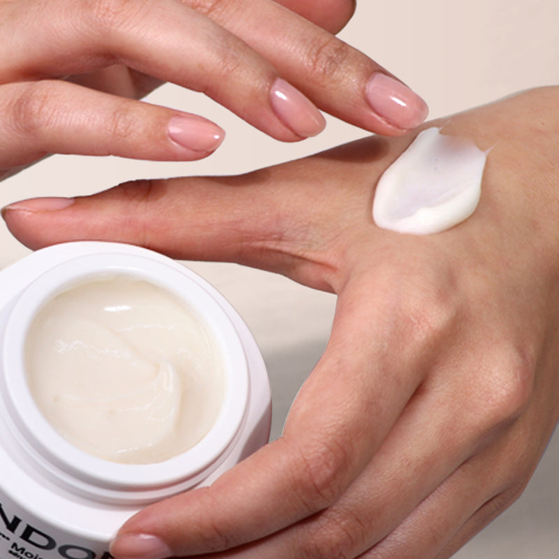 A person is applying a jar of LONDONTOWN's Moisture Renew Hand Serum onto their driest hands.