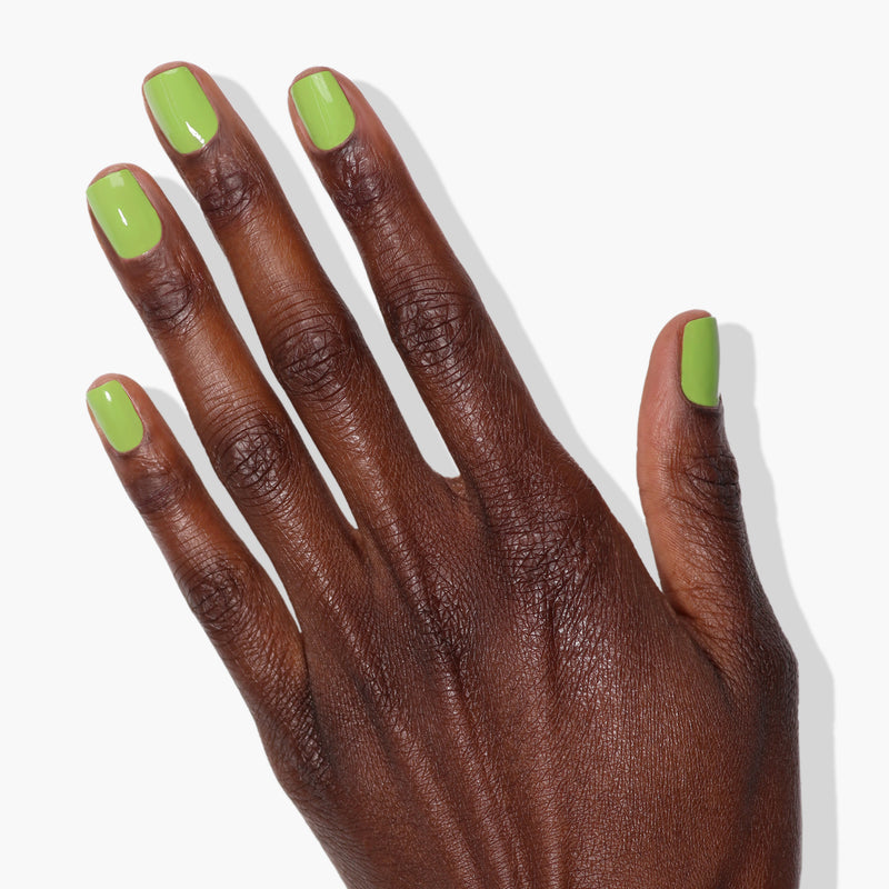 A hand with "Tipsy Mermaid" nail polish by LONDONTOWN on all five neatly manicured nails, reminiscent of a parakeet's vibrant feathers, shown against a white background.