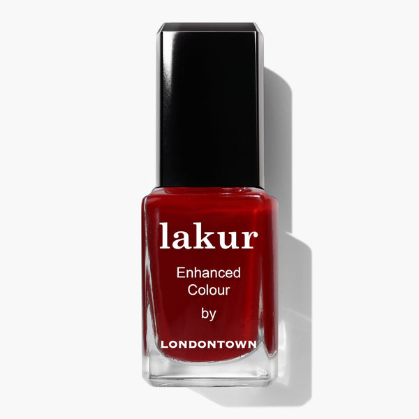 A bottle of LONDONTOWN Lakur Enhanced Colour nail polish in the Truly Ruby deep red shade with a black cap, shown against a white background.