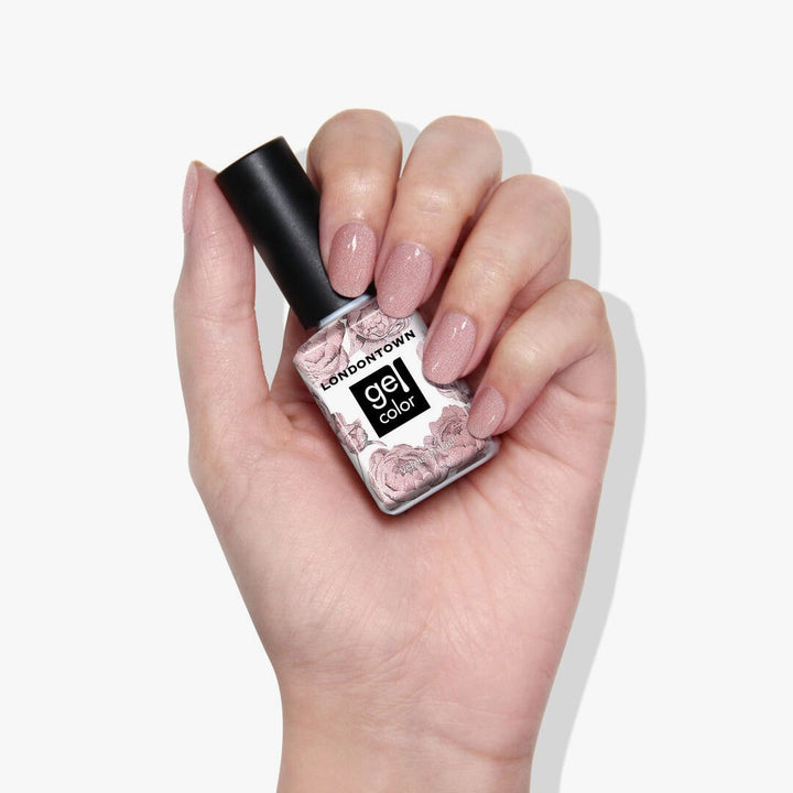 A hand gracefully holds a bottle of LONDONTOWN&