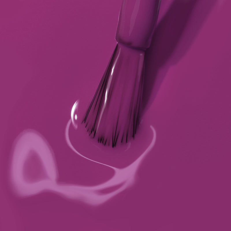 Close-up of a paintbrush applying vibrant Violet Hibiscus from LONDONTOWN on a flat surface, enhanced by UV light, with some streaks and blotches visible.