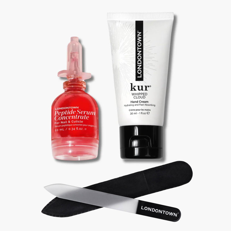 The LONDONTOWN Peptide Nail Repair Set—featuring serum concentrate, Kur Whipped Cloud hand cream, a glass nail file, and black nail buffer—is styled together on a white background for the healthiest nails.