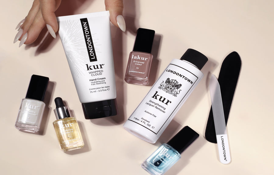 LONDONTOWN Discovery Set flatlay with kur hand cream, lakur polish, kur lacquer remover, cuticle oil, nail treatments and a glass file