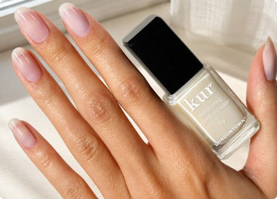 Hand holding a full-size Illuminating Nail Concealer