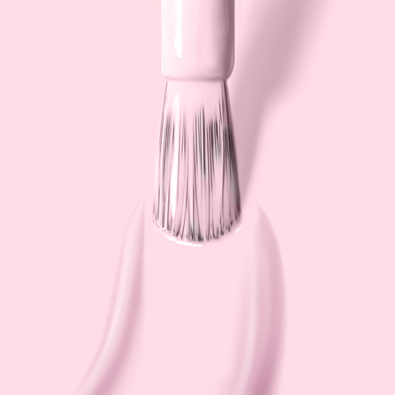 Close-up of a brush applying the light pink crème nail polish "Afternoon Tea" by LONDONTOWN on a smooth surface, with a matching pink background, highlighting its cruelty-free and vegan formula.
