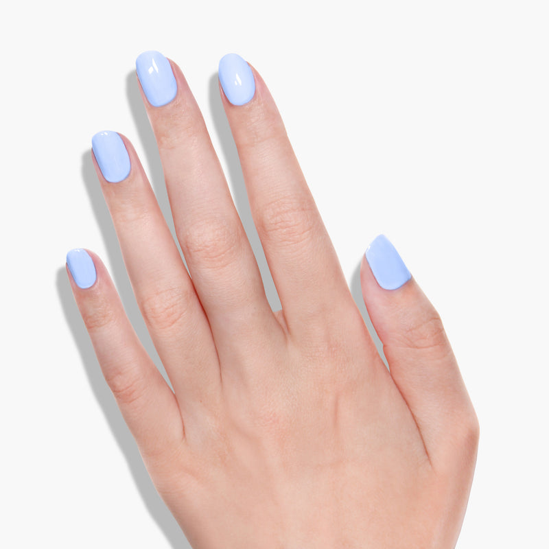 A hand with a cool blue tone, glossy nail polish on all five fingernails against a white background, showcasing the vegan and cruelty-free "Amalfi Love" by LONDONTOWN.