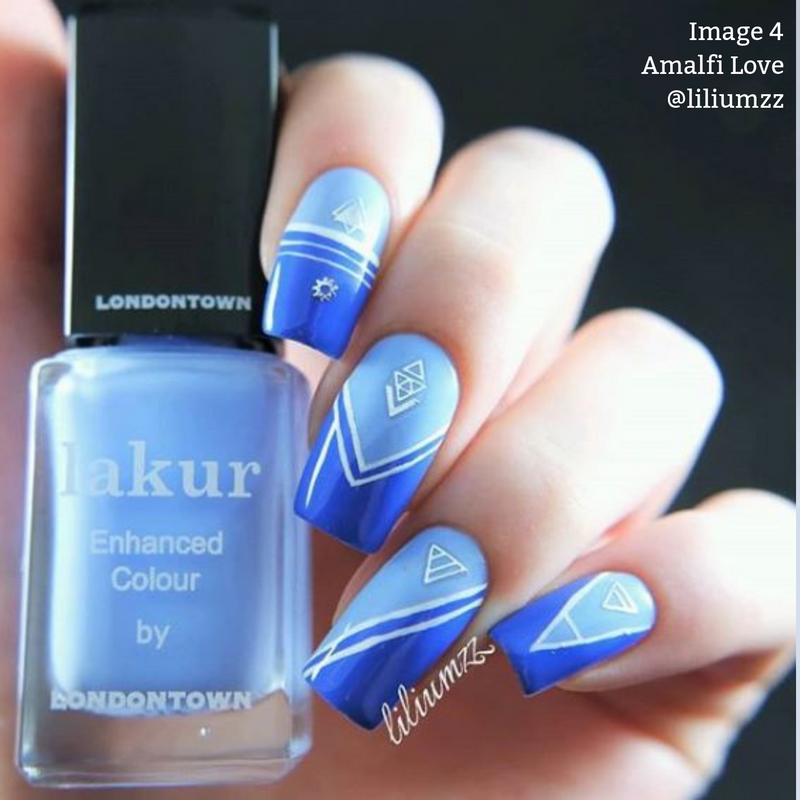 A hand with nails painted in a cool blue tone featuring white geometric designs holds a bottle of LONDONTOWN's Lakur nail polish in the shade "Amalfi Love." This vegan, cruelty-free polish is part of their 16+ Free collection.