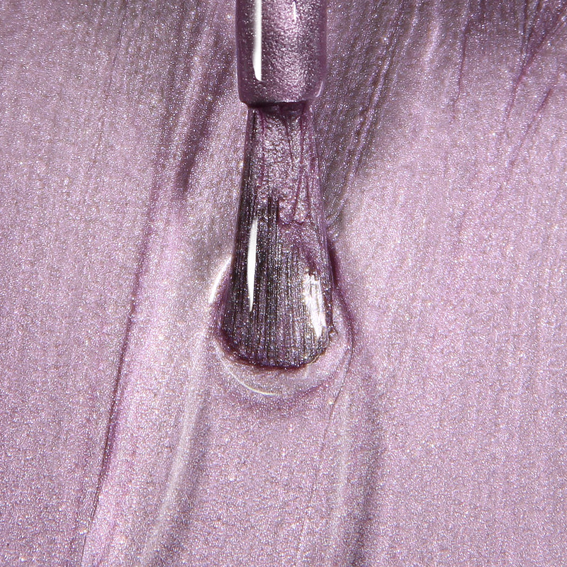Close-up of a brush applying LONDONTOWN's BRILL-ant shimmery, metallic-rose nail polish on a surface.