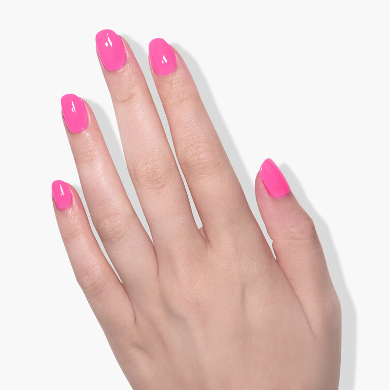 A hand adorned with LONDONTOWN's bold fuchsia, vegan, and cruelty-free polish in the shade Berry Punch is shown against a white background.